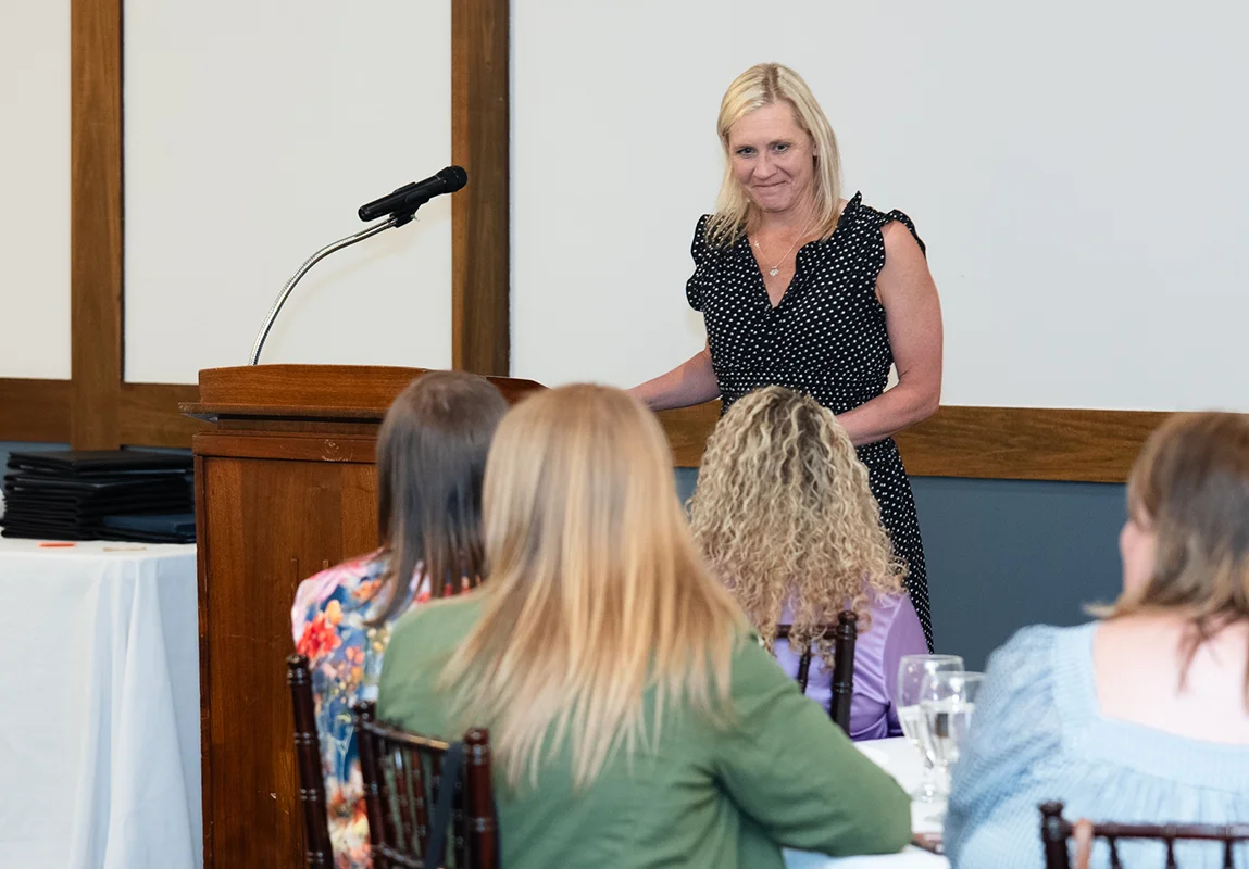 A woman at the podium talking to a group of people